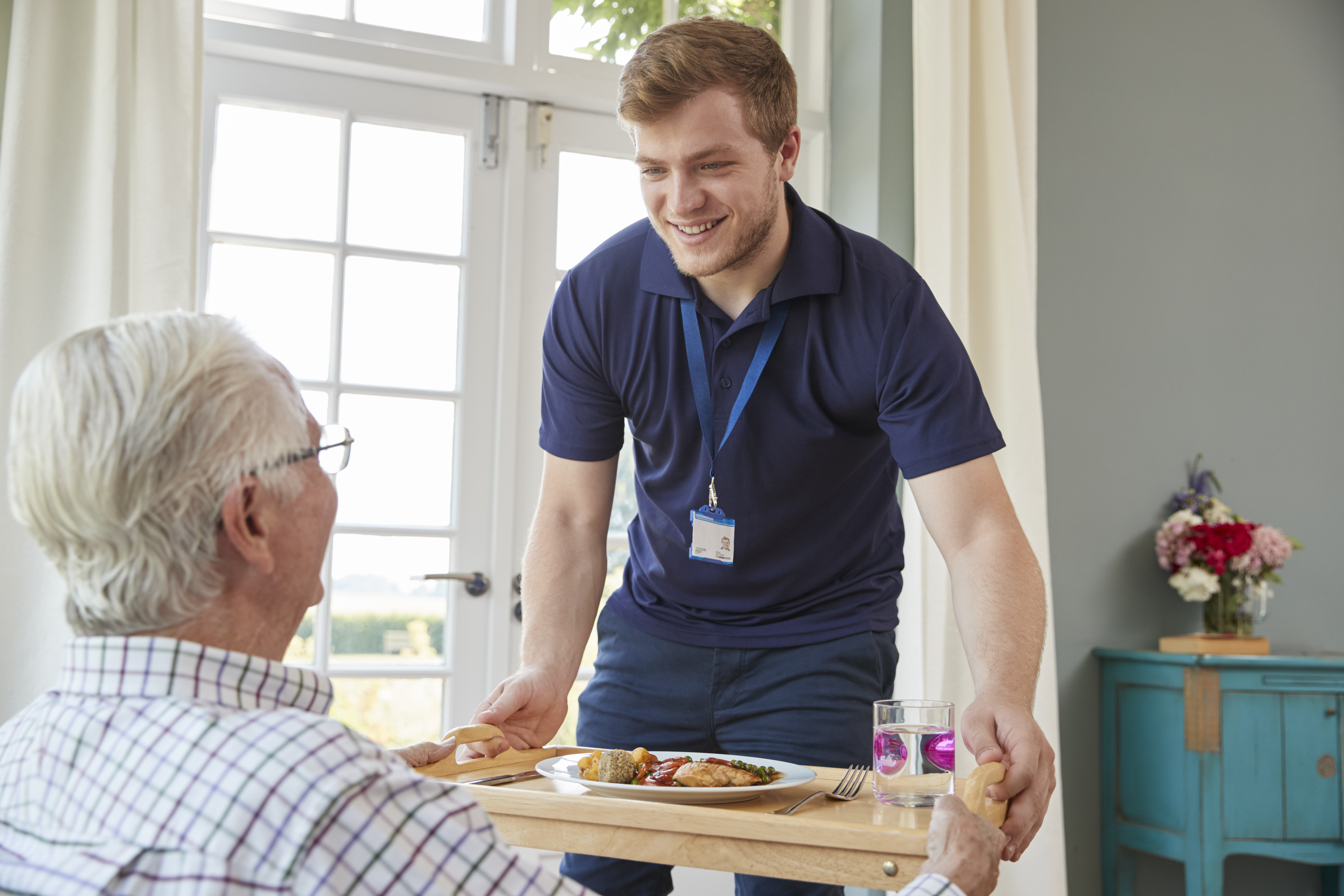 Male Care Worker Serving Dinner To A Senior Man At 2024 10 19 02 13 05 Utc